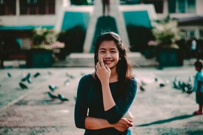 Portrait of young woman standing outdoors