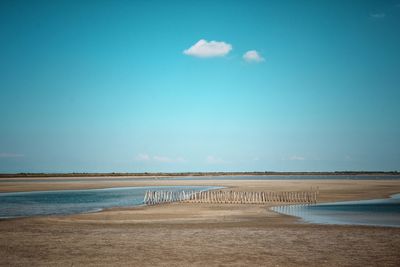 Scenic view of beach against blue sky