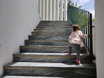 Rear view of baby girl moving up on staircase