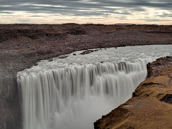 Scenic view of waterfall during sunset