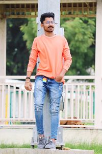 Full length portrait of young man standing against built structure