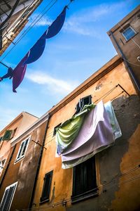 Low angle view of clothes drying on building against sky