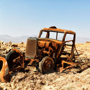 Old machinery on field against sky