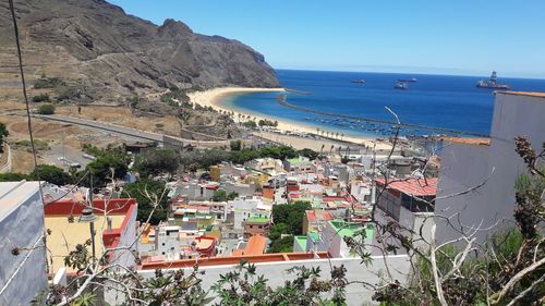 High angle view of townscape by sea against sky