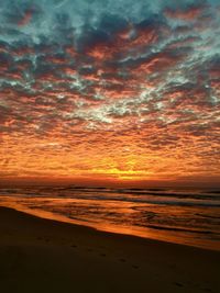 Scenic view of sea against dramatic sky during sunset