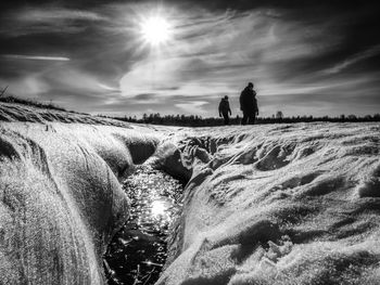 Unrecognizable people walking through snow mountain. snowy park, winter walk. natural background. bw