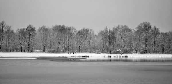 Scenic view of lake against sky during winter