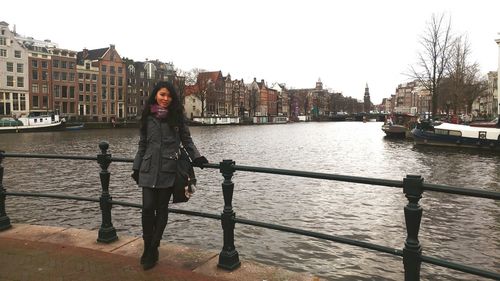 Portrait of young woman on railing in river