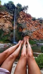 Low section of woman relaxing on rock