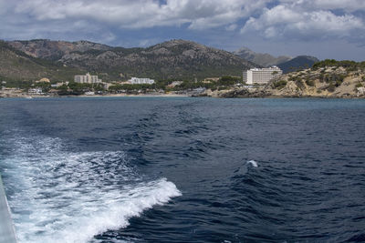 Scenic view of sea by buildings against sky