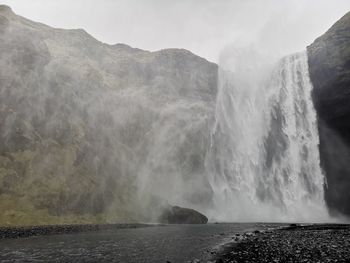 Scenic view of waterfall against mountains