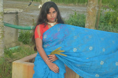 Portrait of woman standing against blue wall