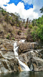 Scenic view of waterfall against sky