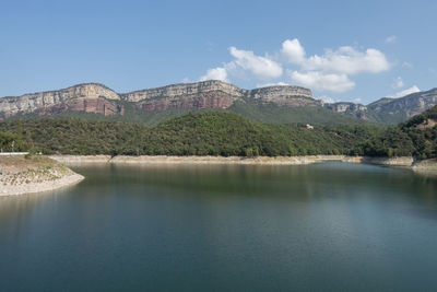 Scenic view of lake by mountain against sky