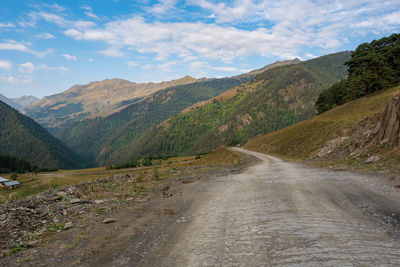 Road leading towards mountains against sky