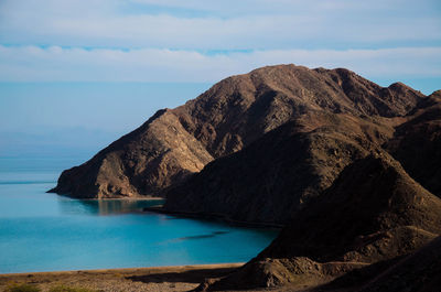 Scenic view of sea and mountains against sky