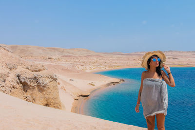 Woman standing against beach