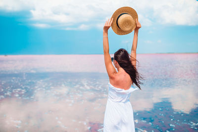 Woman looking at sea against sky