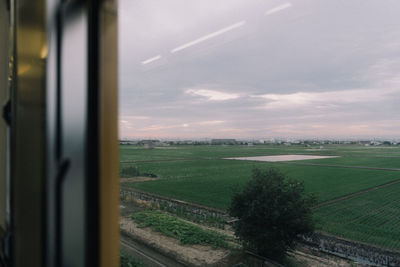 Scenic view of field seen through train window