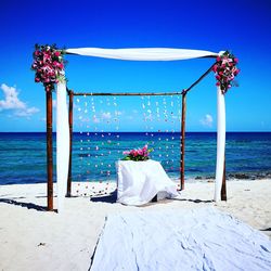 Wedding decoration at beach against clear sky