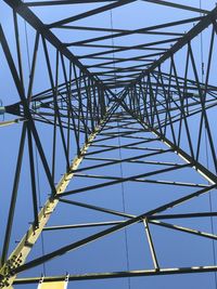 Low angle view of electricity pylon against clear sky