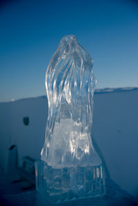 Close-up of ice crystals on sea against clear blue sky