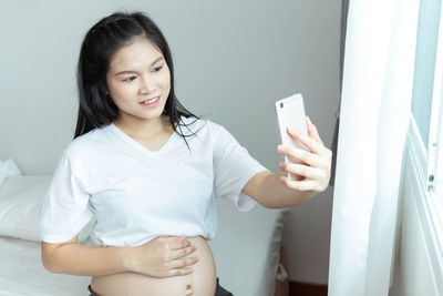 Portrait of smiling young woman using mobile phone