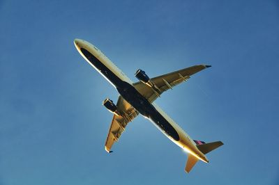 Low angle view of airplane flying against sky