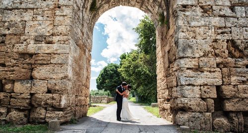 Full length of woman photographing against sky