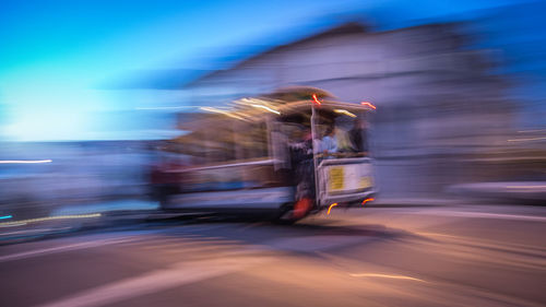 Blurred motion image of cable car on street at dusk