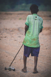 Rear view of boy standing on land
