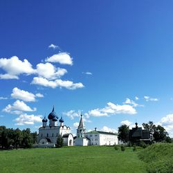 Built structure on field by buildings against sky