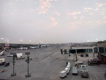 Airplane on airport runway against sky in city