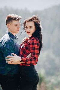 Loving young couple standing in forest