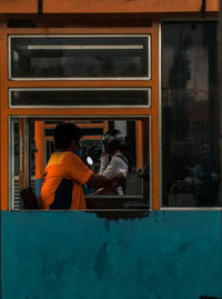 Reflection of man standing on glass window