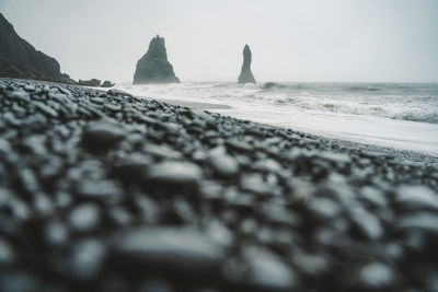 Surface level of rocks on beach against sky