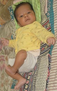 Portrait of cute baby girl lying on bed