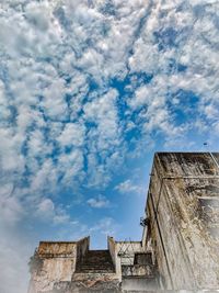 Low angle view of old building against cloudy sky