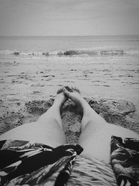 Low section of man relaxing on beach