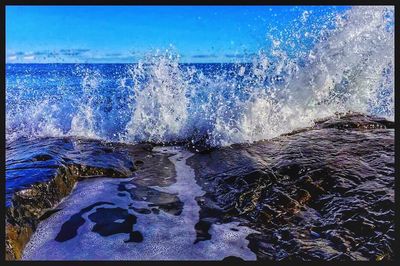 Close-up of sea waves against blue sky