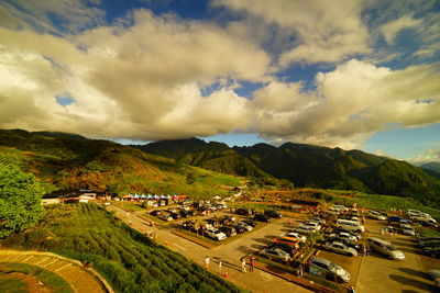 Houses on mountain against cloudy sky