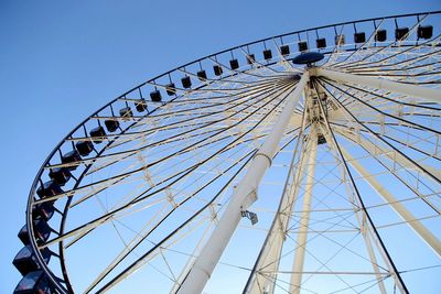 Low angle view of ferris wheel against blue sky