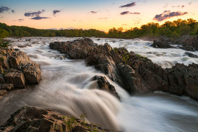 Scenic view of waterfall against sky during sunrise in great falls national park - washington dc