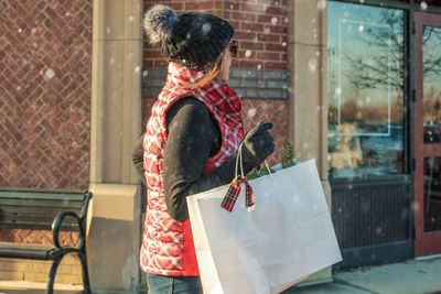 Woman with umbrella in city during winter