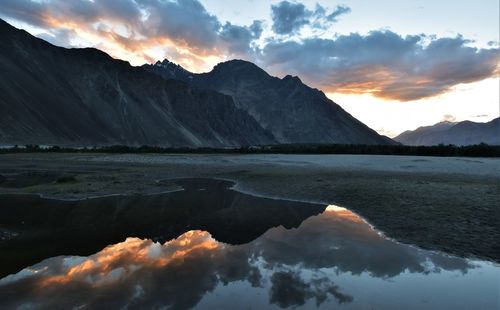 Scenic view of mountains and lake against sky during sunset