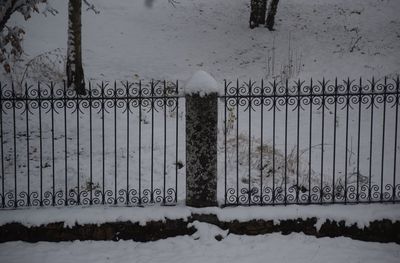 Snow on metal fence during winter