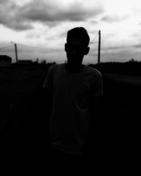 Man standing by car against sky