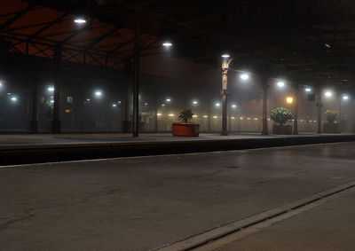 Illuminated street lights on road in city at night