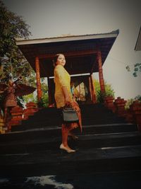 Full length of woman standing on staircase against building