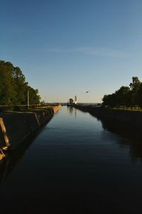 Scenic view of river against clear sky at sunset